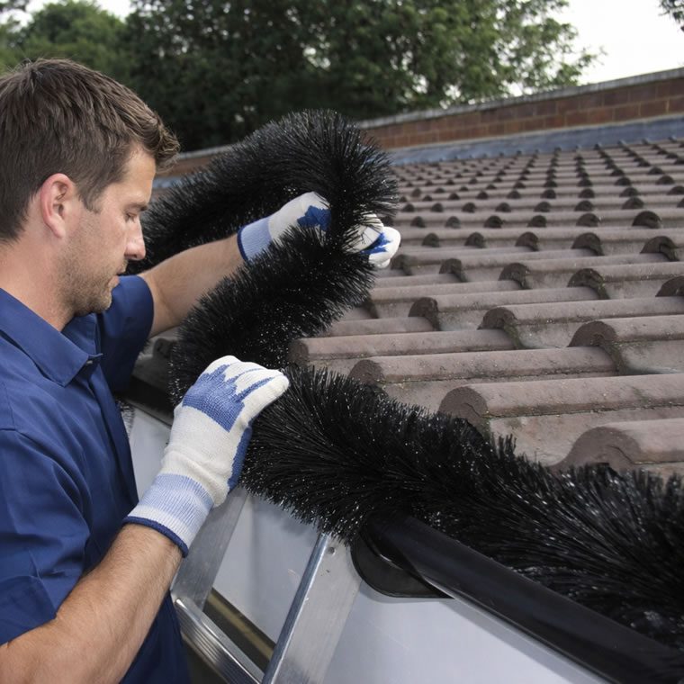 roofer installing gutter brush guard